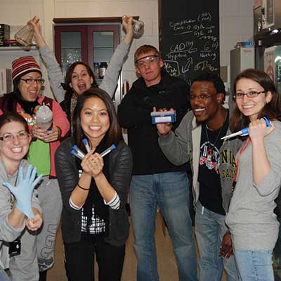 smiling students having fun together in a forensic science lab