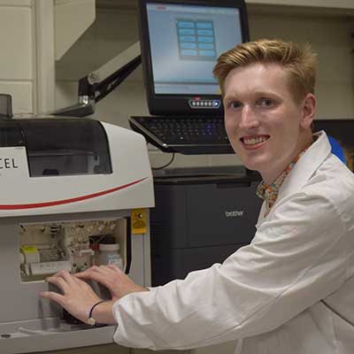 a student in a lab working on a piece of lab equipment