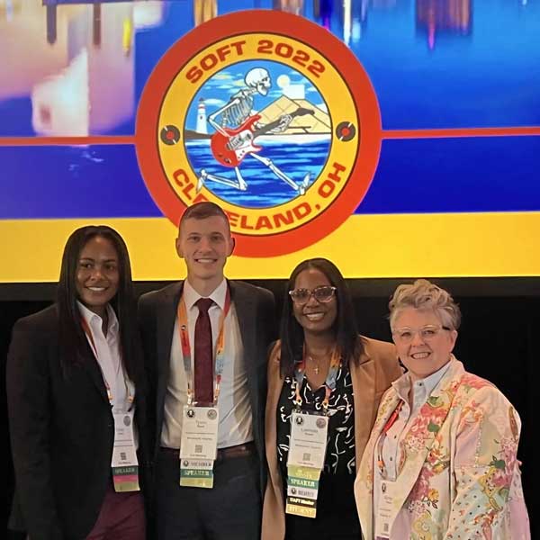 four v.c.u. forensic science researchers standing together at an academic conference